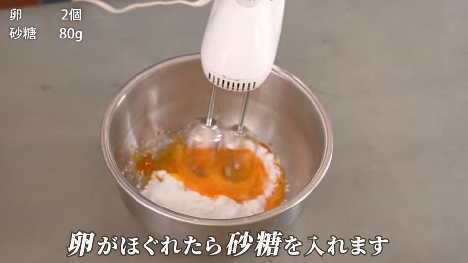 卵と砂糖をマヨネーズ状に泡立てる場面
