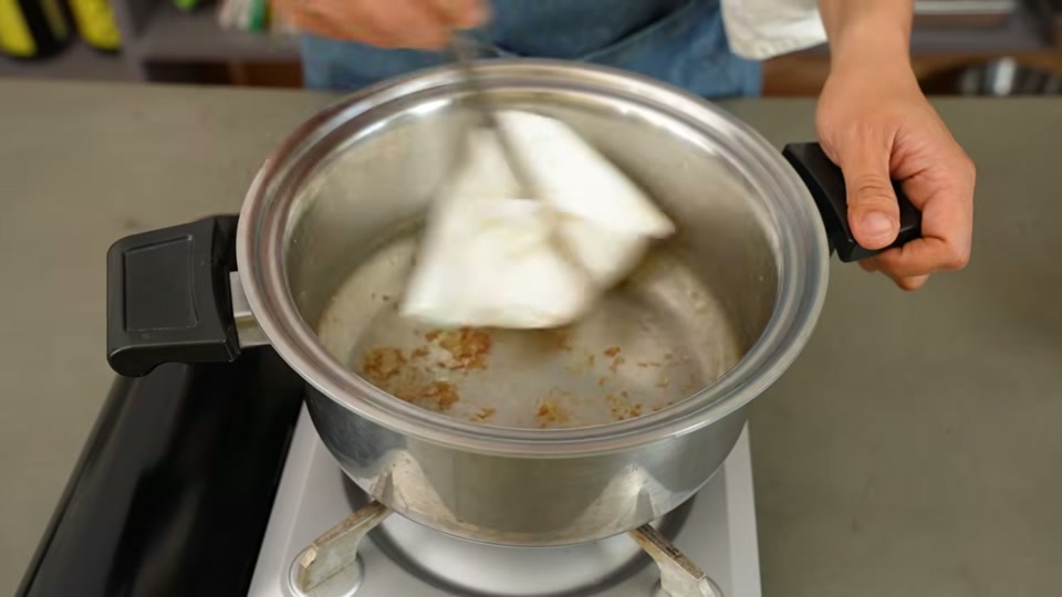 油を捨てた後ペーパーで鍋を拭く作業