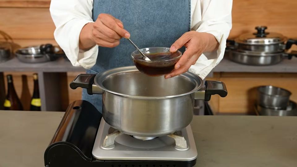 特製ダレを鍋に注ぎ入れて加熱するシーン