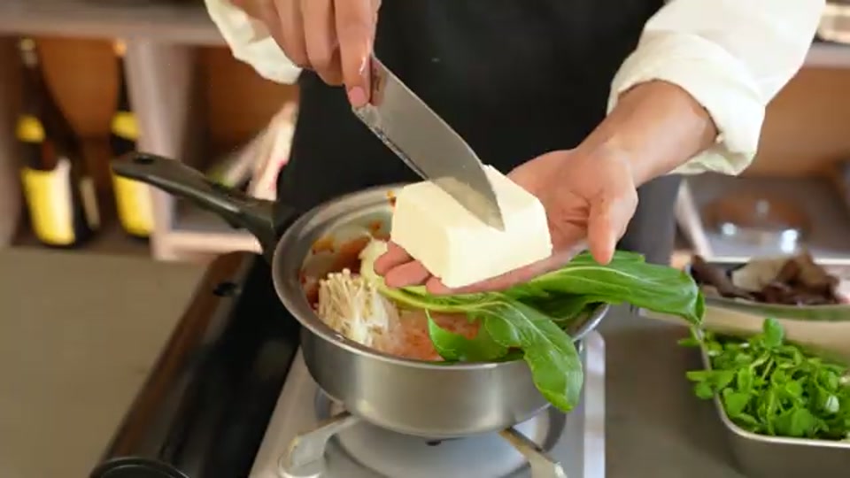 具材を鍋に投入し煮込むシーン