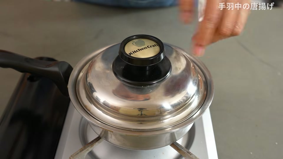 蓋を外してカリッと揚がった手羽中をひっくり返す場面