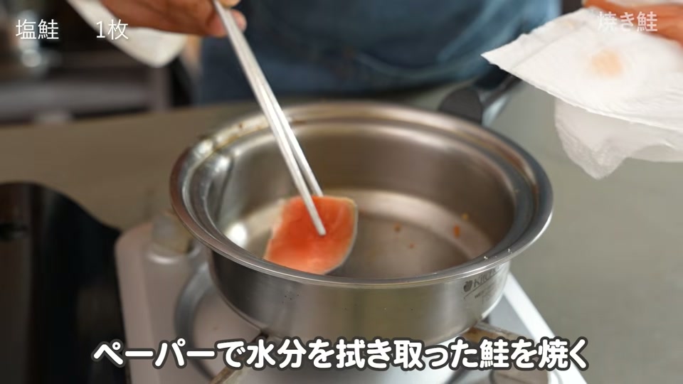 油を拭き取った温かい鍋で鮭の蓋焼きを開始する場面