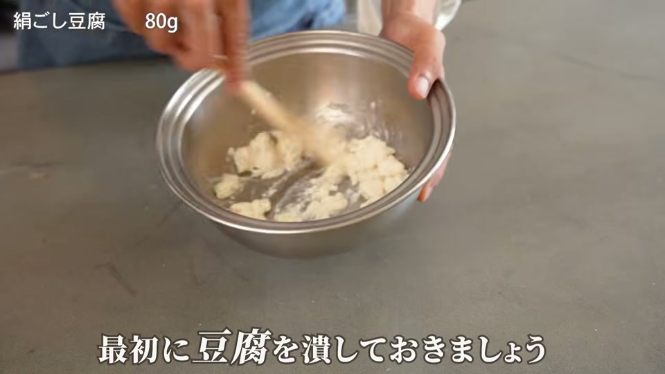 絹ごし豆腐をヘラで滑らかに潰す場面