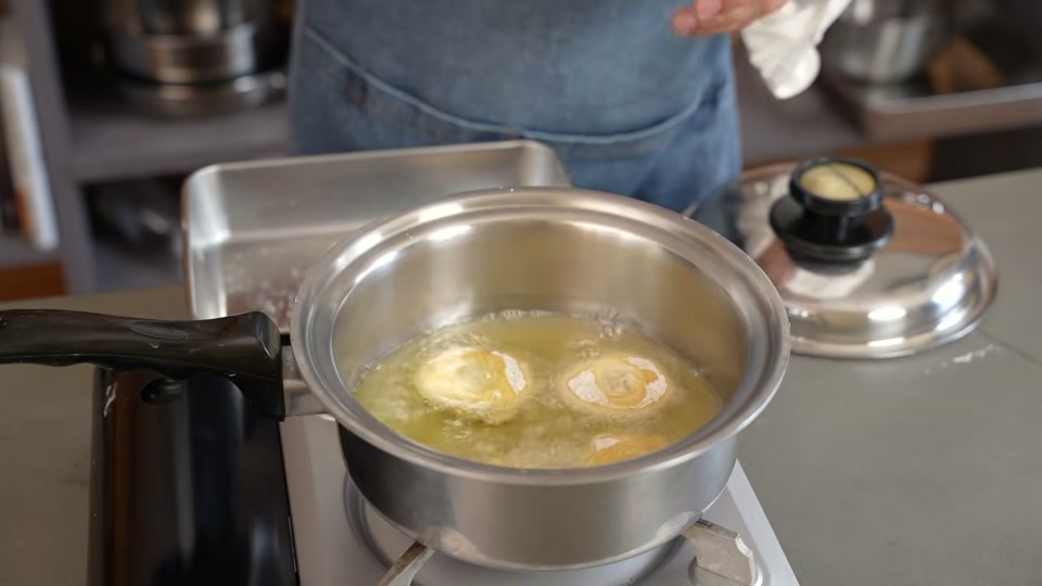 少量の油でドーナツ生地を揚げる場面