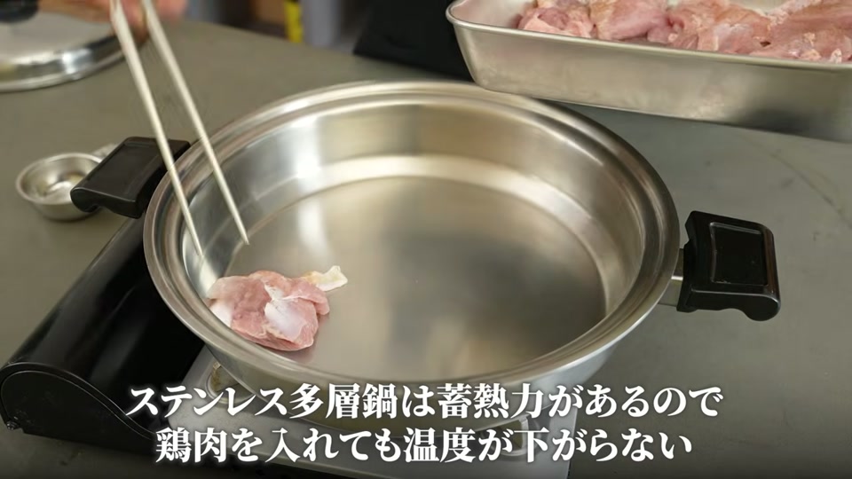 鶏肉を皮目からフライパンに入れる場面